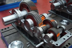 Componentes de reductor industrial en banco durante reparación, rearmado y verificación para retorno a servicio