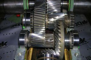 Tren de engranajes helicoidales de reductor industrial, reparación en taller con revisión de desgaste y reemplazo de componentes